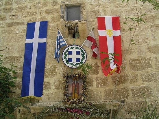 Флаги, греческий и святогробский, над входом в монастырь святого Герасима